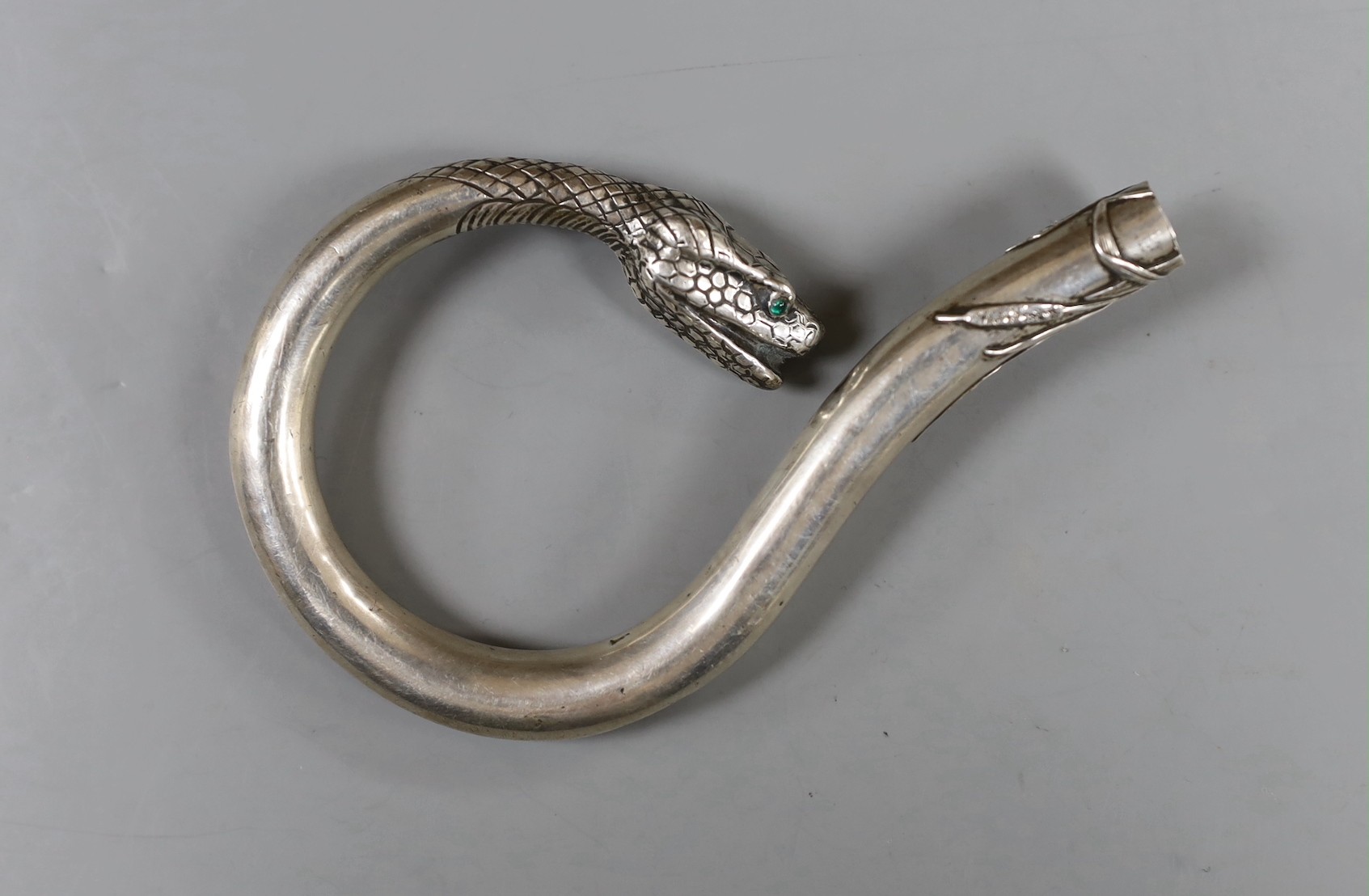 A Japanese? white metal cane handle, with cabochon eyes and terminal modelled as the head of a serpent, 12.2cm, gross weight 55 grams.